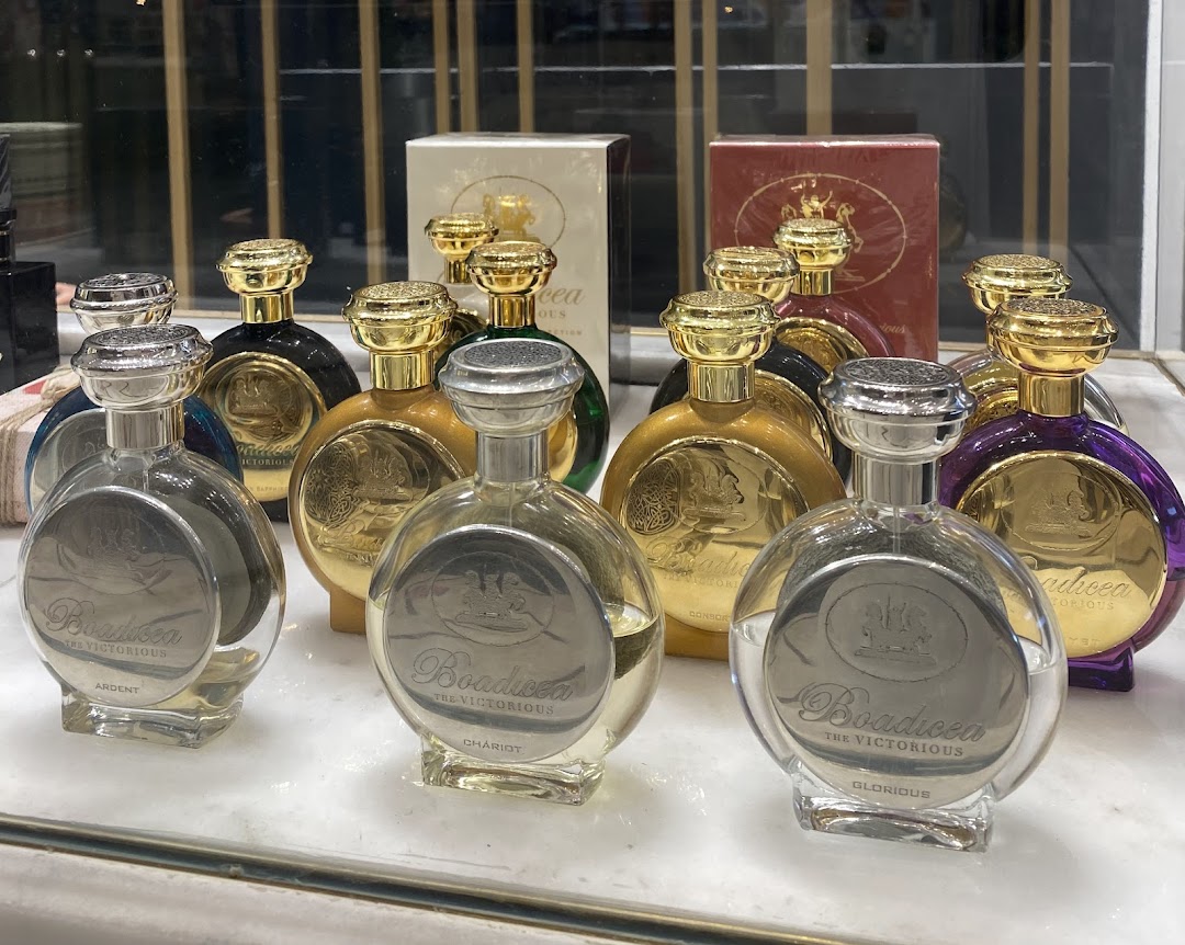 A collection of Boadicea the Victorious perfume bottles with ornate gold caps and distinctive labels.