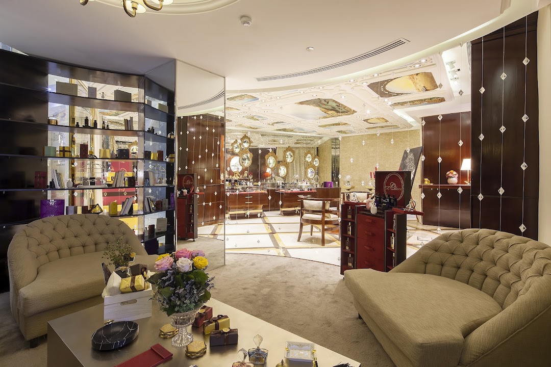 Luxurious interior of a perfume shop with elegant seating and display shelves.