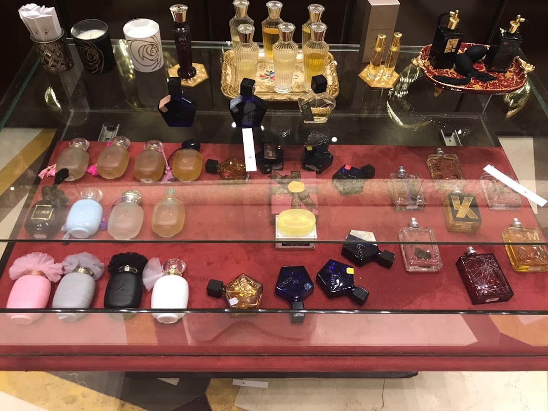A display case filled with various perfumes and scented candles, showcasing elegant bottles and packaging.