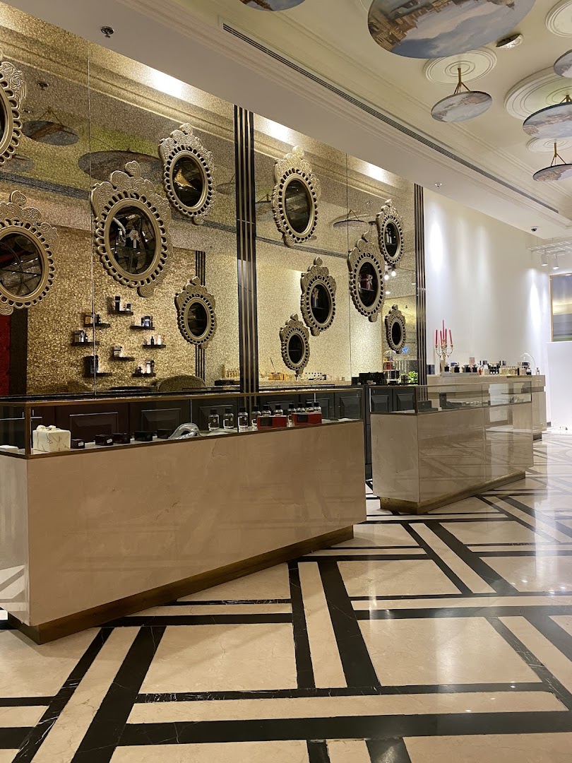 Interior of a luxurious shop with ornate mirrors and display counters showcasing products.