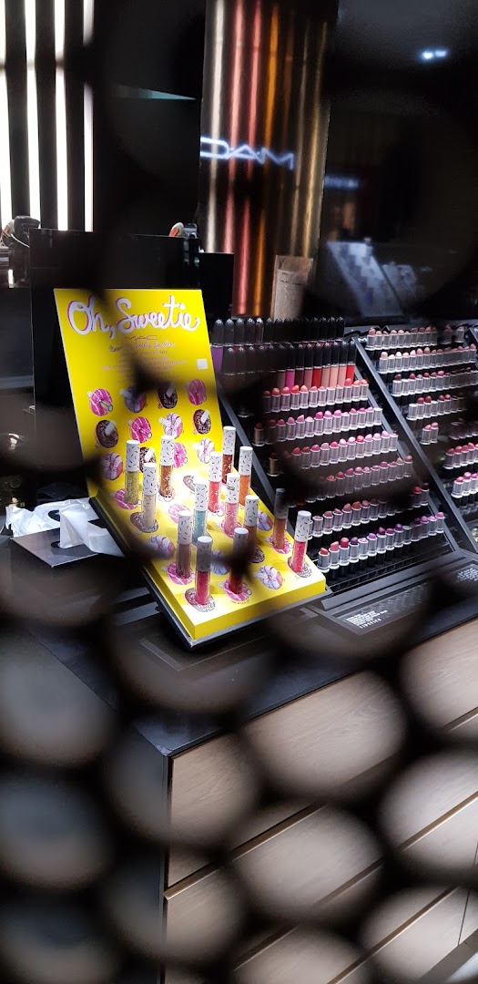 A display of M.A.C lipsticks and glosses with a 'Oh, Sweetie' themed promotional stand.