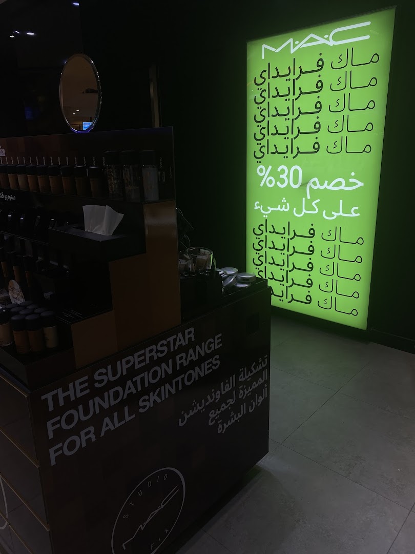 A M.A.C store display featuring foundation and a promotional sign with Arabic text.