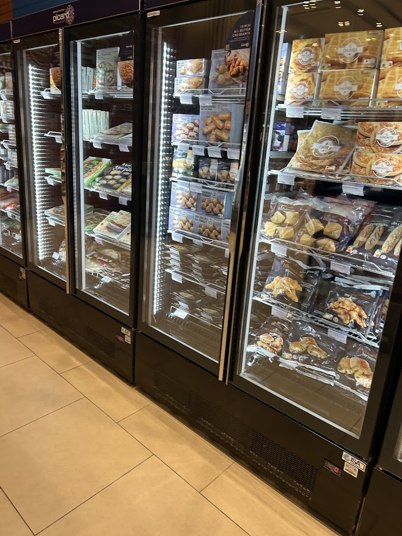 Refrigerated display cases filled with various frozen food items, including pastries and meals.
