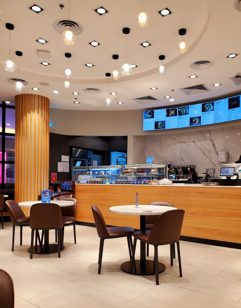 Interior view of MS FOOD and MS CAFE with seating, counter, and digital menu board.
