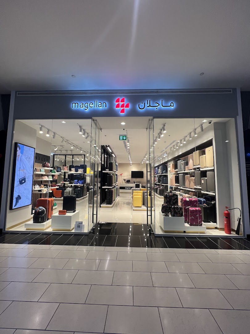 The storefront of Magellan, a luggage and travel accessories store, displaying various suitcases.