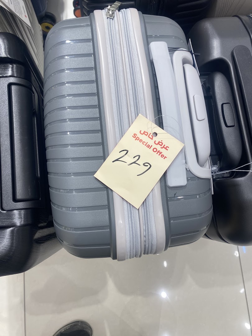 A close-up of a grey suitcase with a yellow tag indicating a special offer and price.