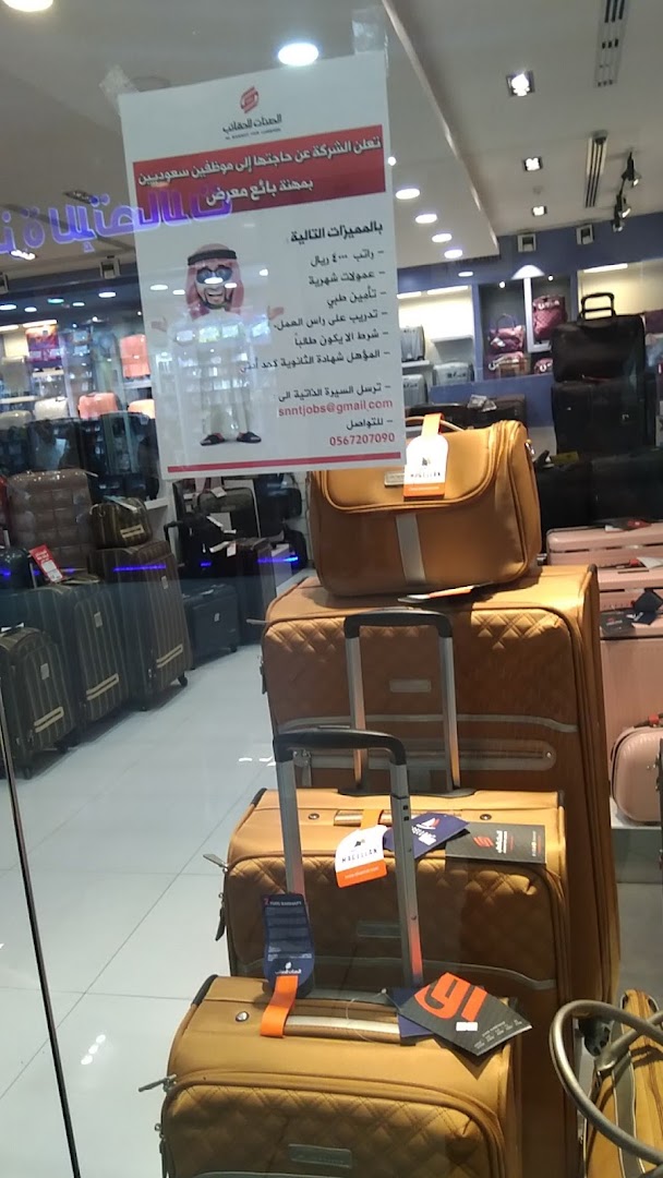 A display of luggage inside a store, with a recruitment poster visible.