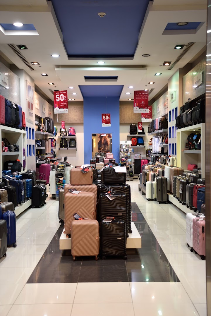 Interior view of a luggage store showcasing a wide variety of suitcases and bags.