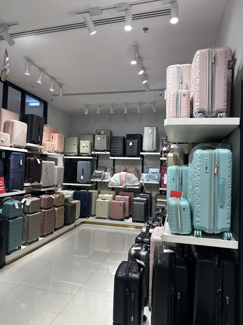 A wide selection of suitcases in various colors and sizes are neatly displayed on shelves and the floor.