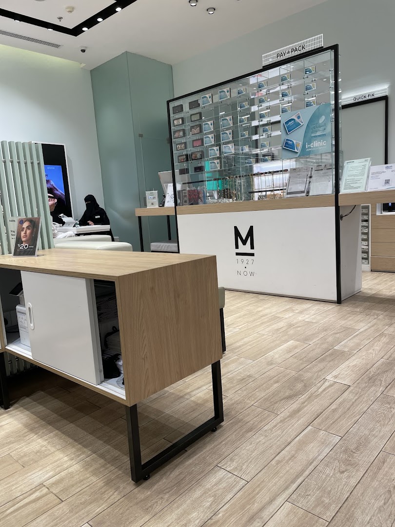 Interior of an optical shop with displays of eyewear and a counter.