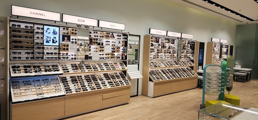 A well-lit optical shop interior showcasing a wide selection of designer sunglasses and eyeglasses.