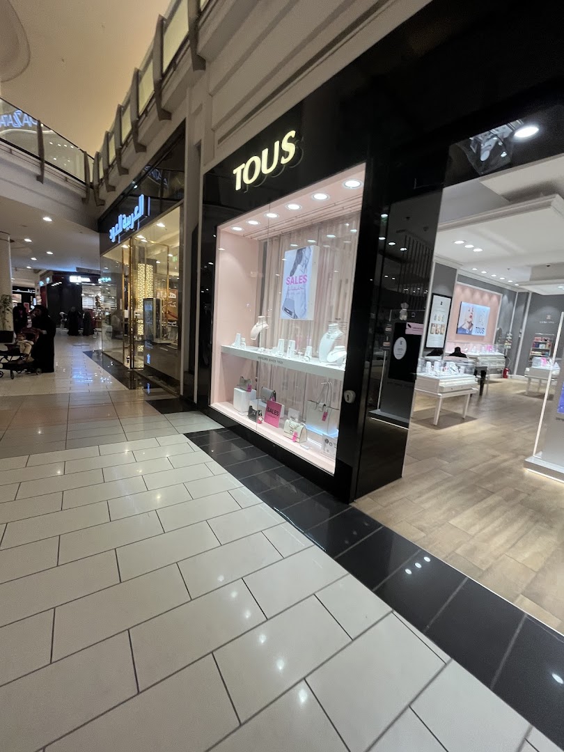 The exterior of a TOUS jewelry store with a display window showcasing jewelry and bags.