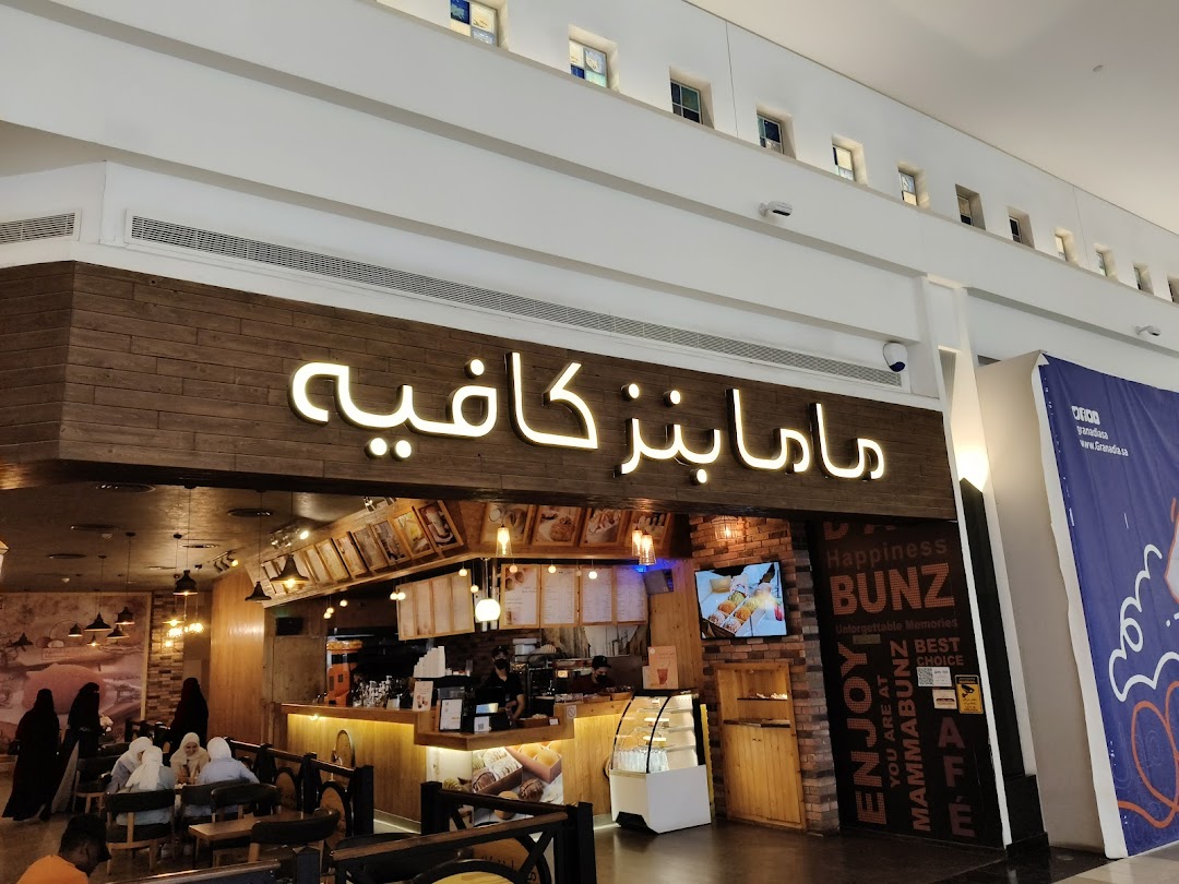 The exterior of MammaBunz Cafe, a cozy coffee shop with a warm wooden facade and inviting seating.