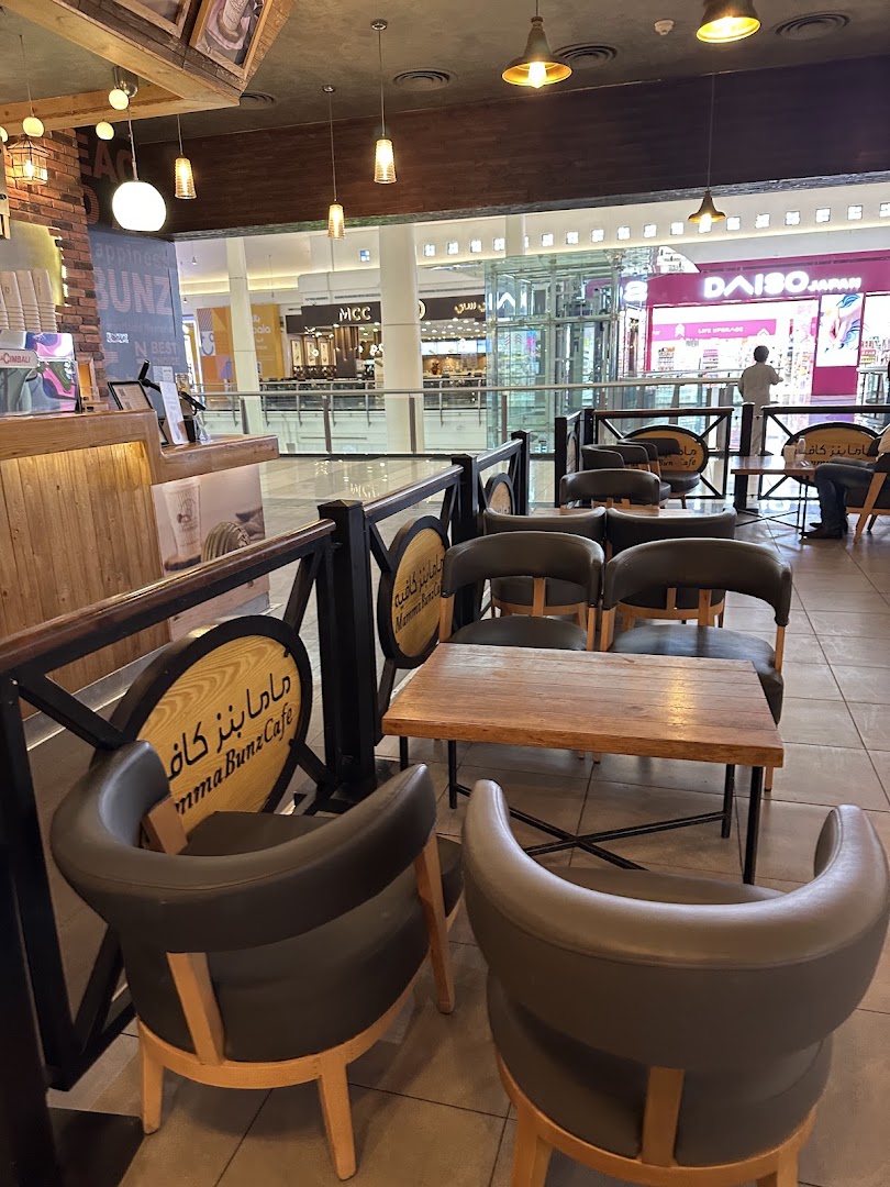 Interior seating area of MammaBunz Cafe with tables and chairs, overlooking a mall.