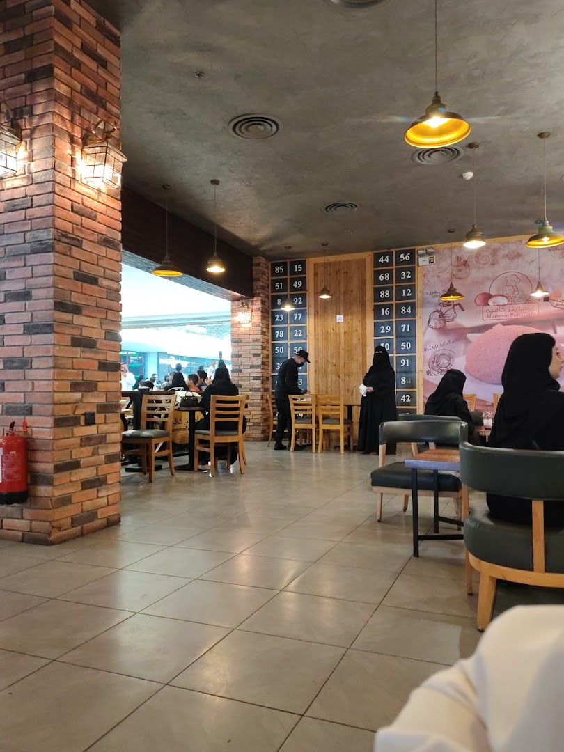 Interior view of MammaBunz Cafe with patrons seated at tables and a brick pillar.
