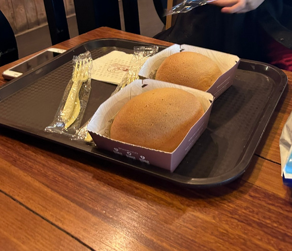 Two freshly baked buns served on a tray with cutlery and napkins.