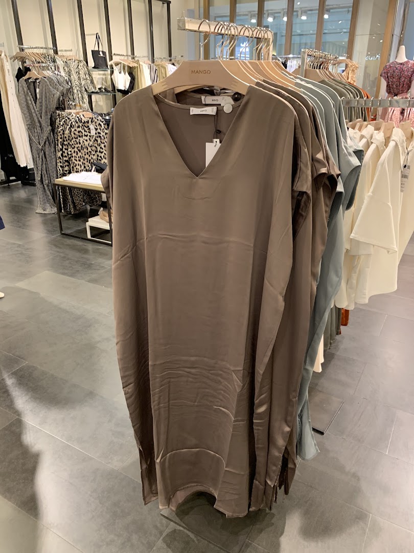 A stylish brown dress is displayed on a hanger in a clothing store.