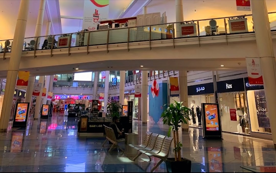 Interior view of a shopping mall with various stores, including Mango and Kios.