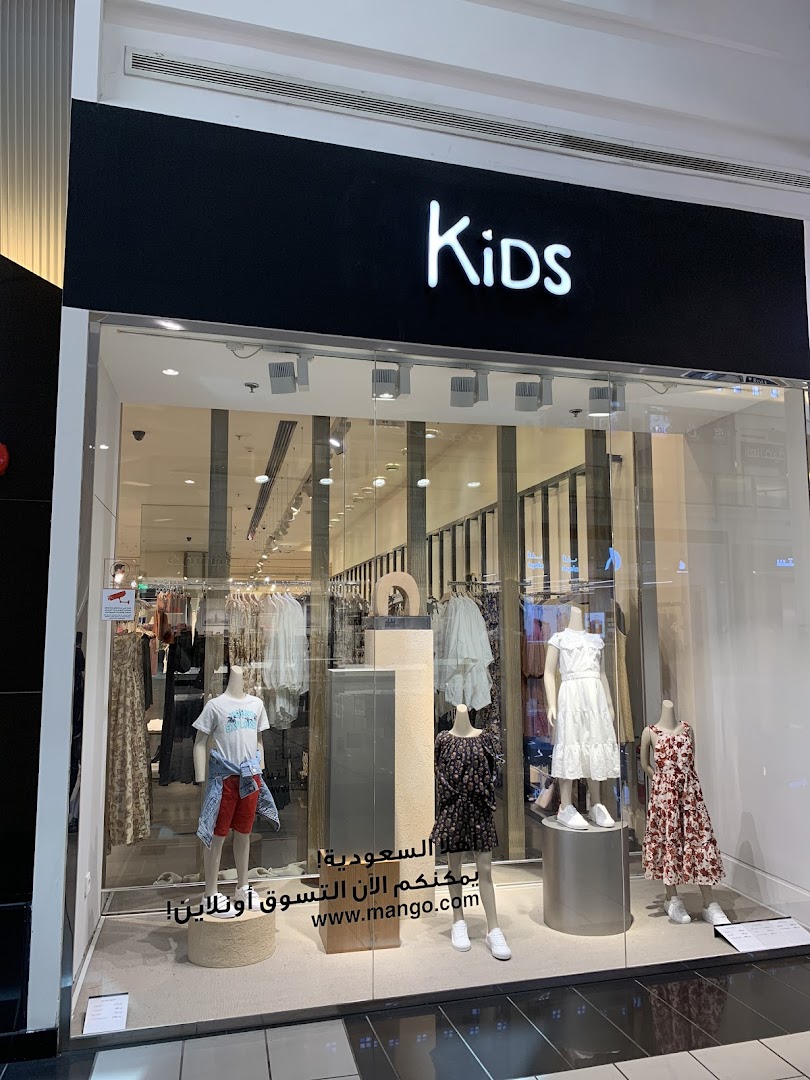 Mango Kids store window display featuring mannequins dressed in stylish children's clothing.