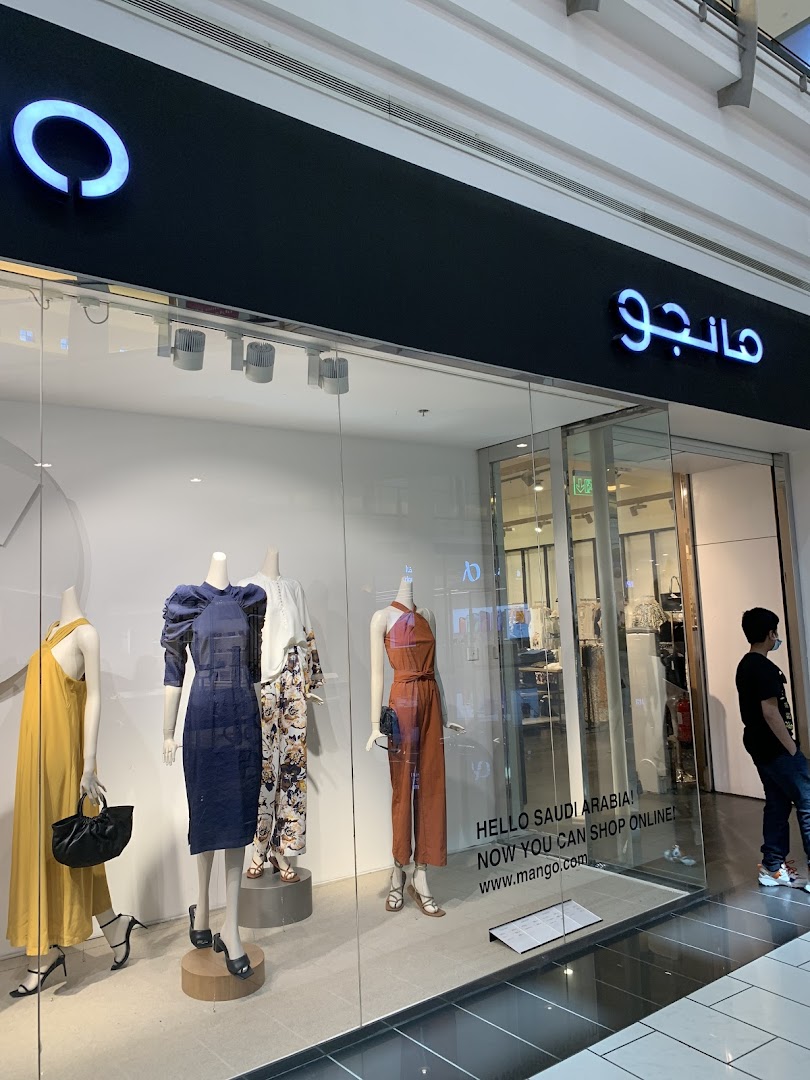Mango store front with mannequins displaying fashionable outfits in the window.