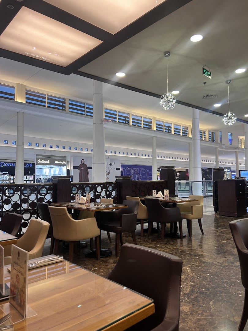 Interior view of a cafe with tables and chairs, showcasing the mall's ambiance.