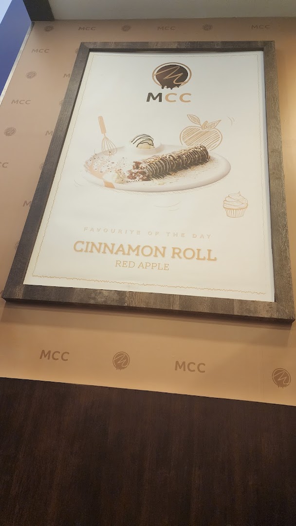 A framed poster advertising a cinnamon roll from MCC.