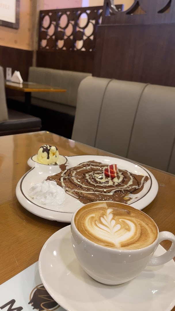 A delicious crepe with chocolate sauce, ice cream, and a latte with latte art.