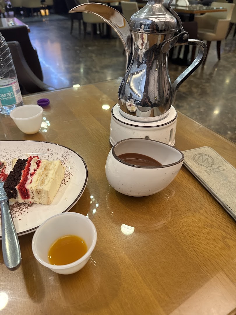 A slice of cake and coffee set on a wooden table at MCC.