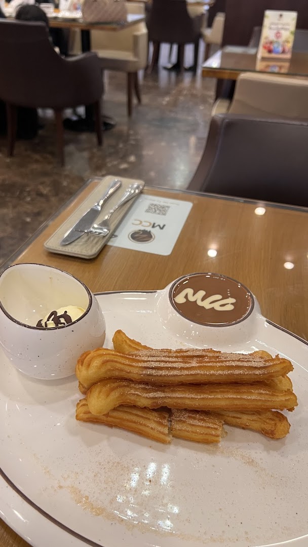 A plate of churros with a side of ice cream and a dipping sauce.