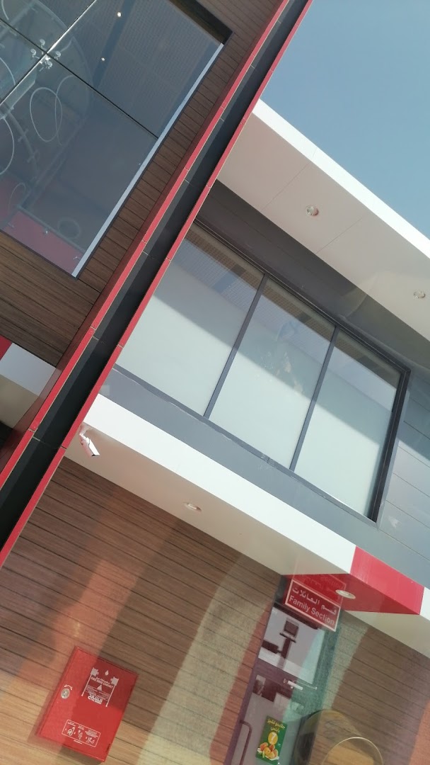 Exterior view of a modern McDonalds restaurant with wood-paneled walls and large windows.