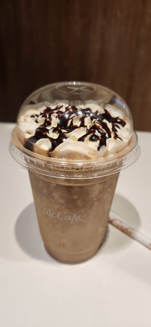 A McCafe frappe topped with whipped cream and chocolate drizzle.