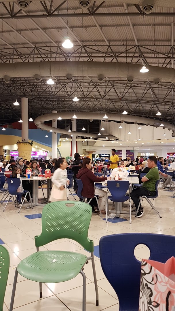 People dining at tables in a busy McDonald's restaurant with a high ceiling.