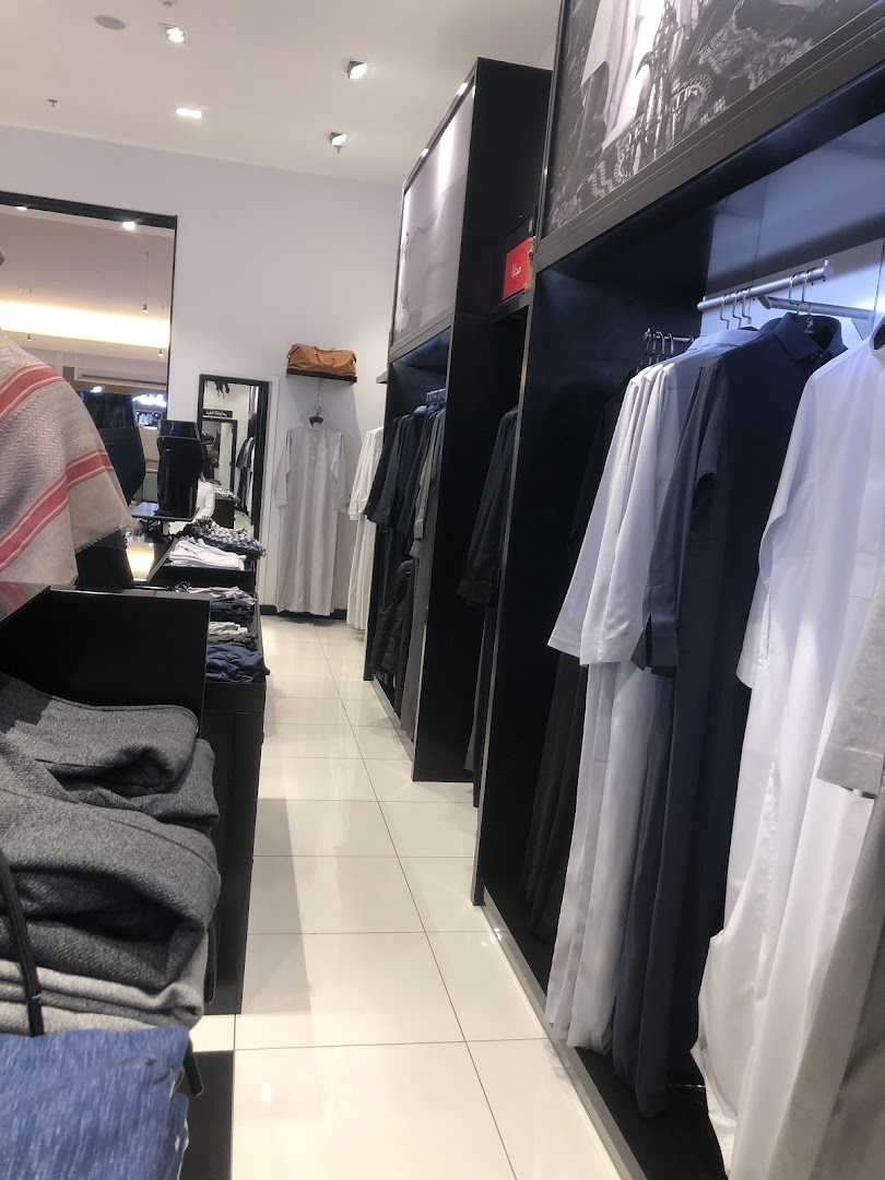 Interior view of a clothing store showcasing traditional men's attire on display racks.