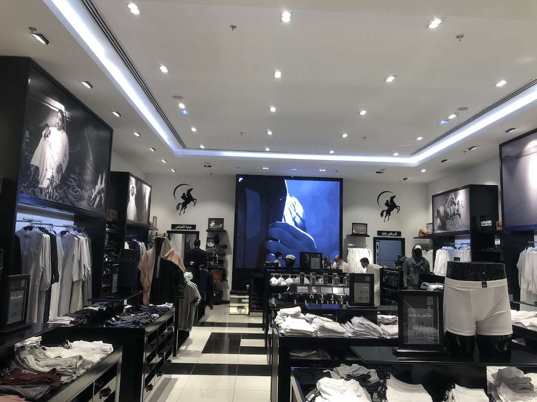 Interior view of a modern clothing store showcasing men's apparel and accessories.