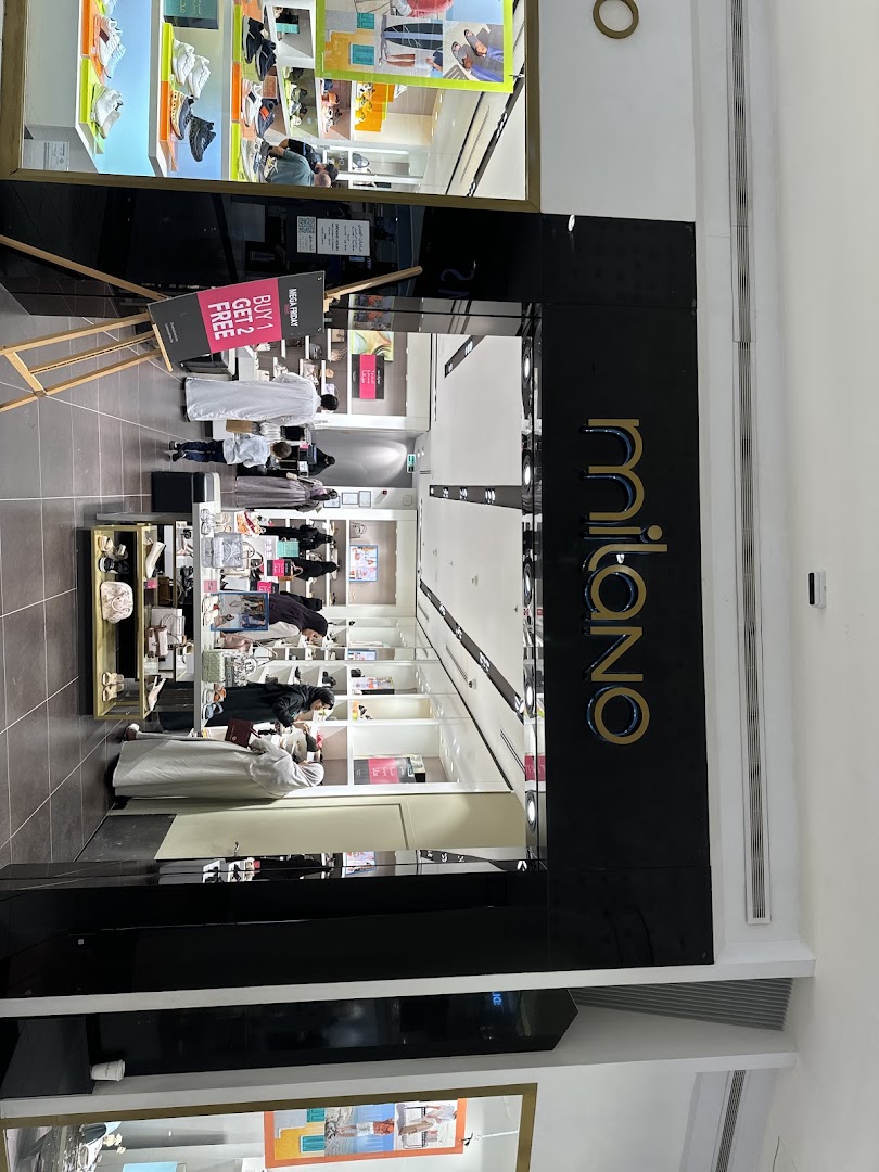 The entrance of the Milano shop, showcasing a sale sign and interior displays of merchandise.
