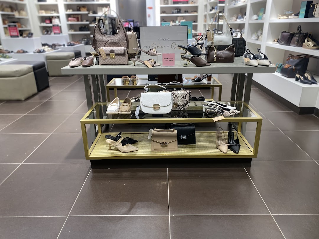 A display of stylish women's shoes and handbags in a retail store.