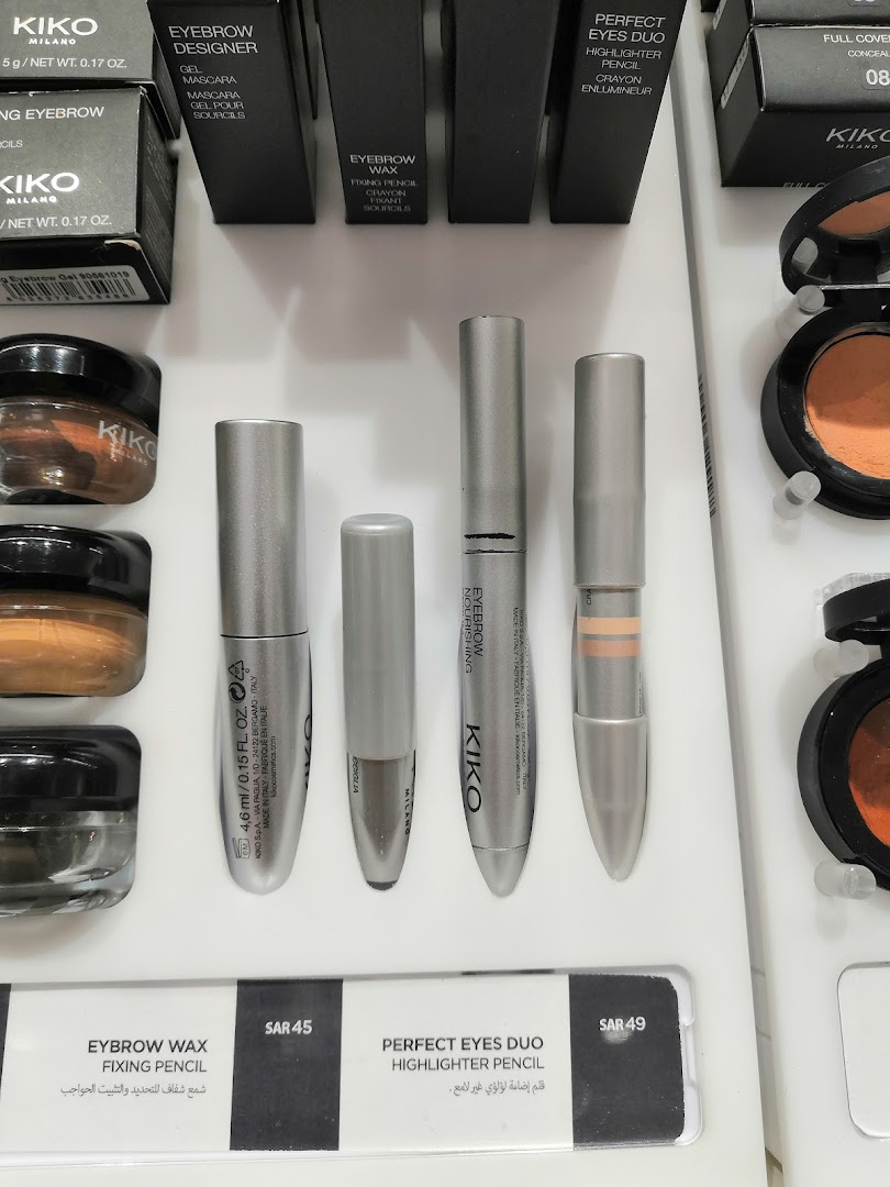 A display of Kiko Milano eyebrow and eye makeup products, including gels, pencils, and eyeshadows.