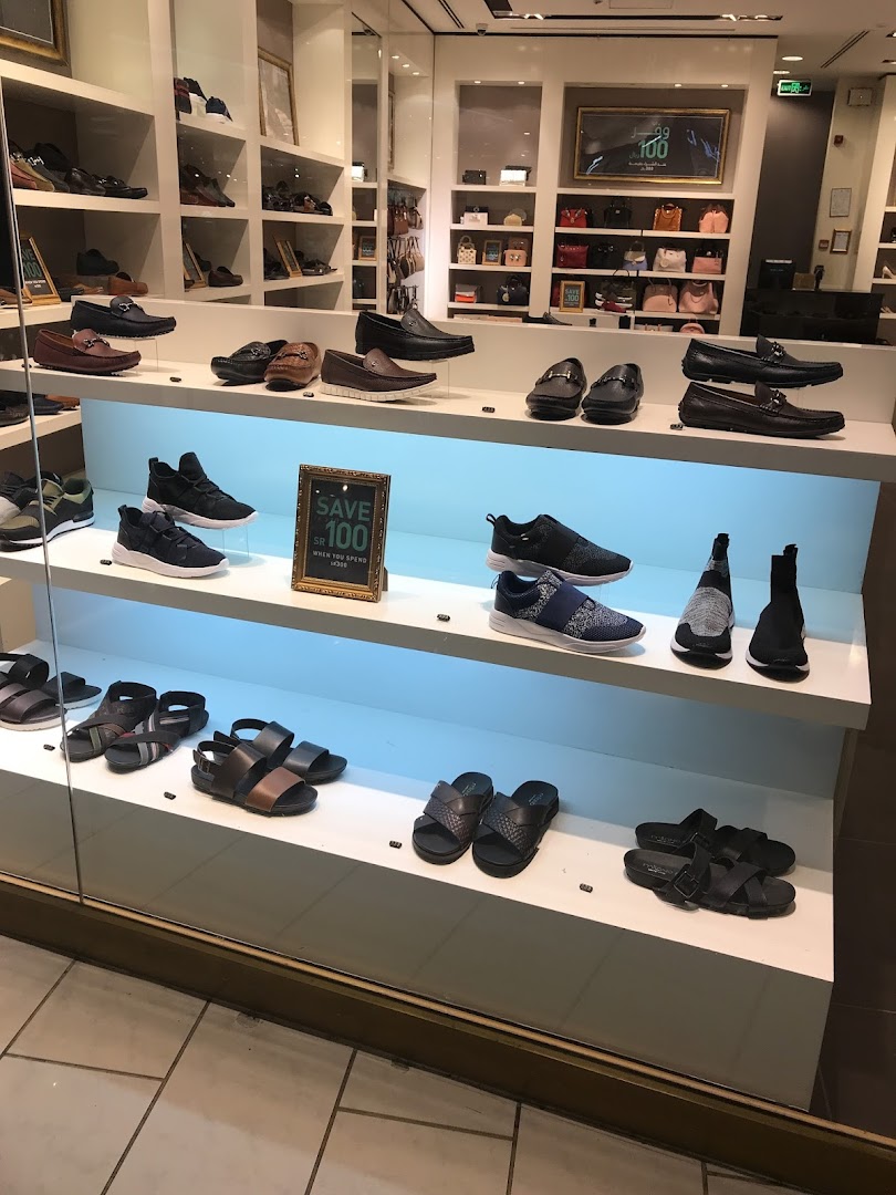 A display of various shoes and handbags in a retail store.