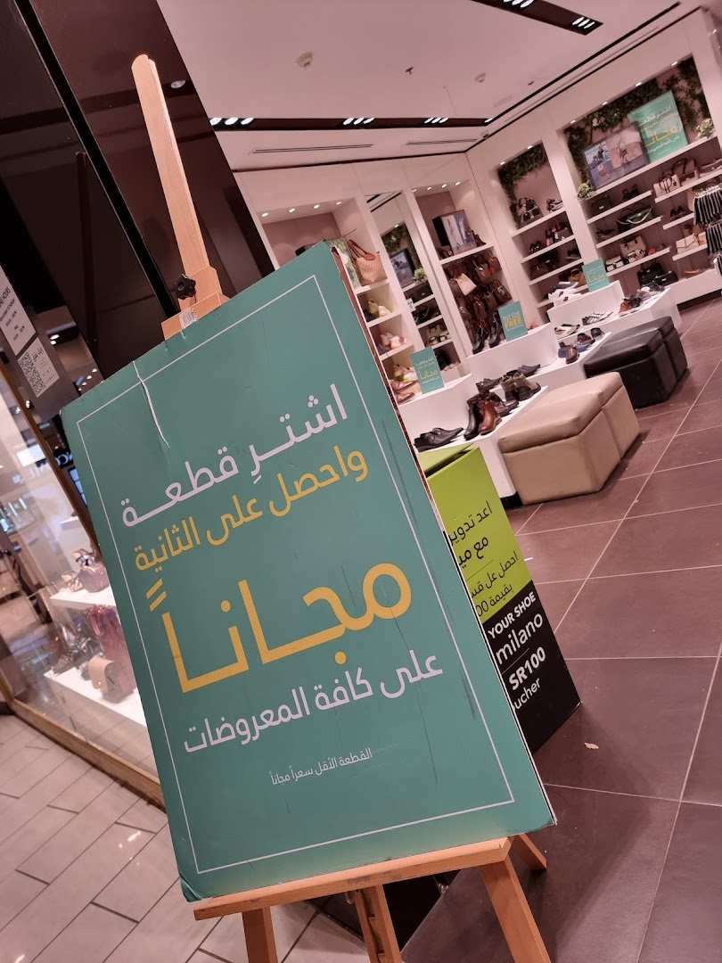 A shop interior with shoes displayed on shelves and a promotional sign.