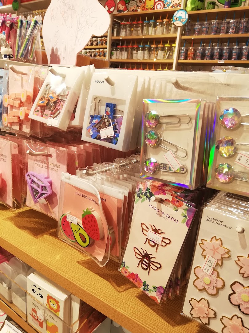 A display of cute stationery items like erasers, paper clips, and stickers at MINISO.