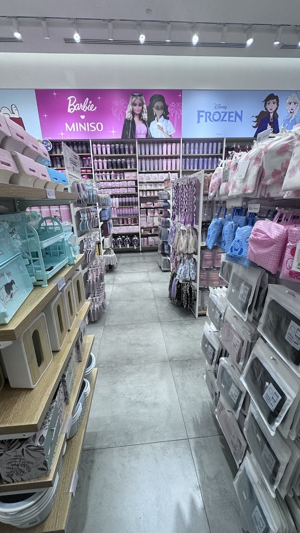 Interior view of a MINISO store showcasing shelves filled with various products, including Barbie and Frozen merchandise.