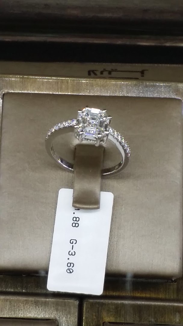 A stunning diamond ring with a central cluster of square-cut diamonds and a band of smaller diamonds.