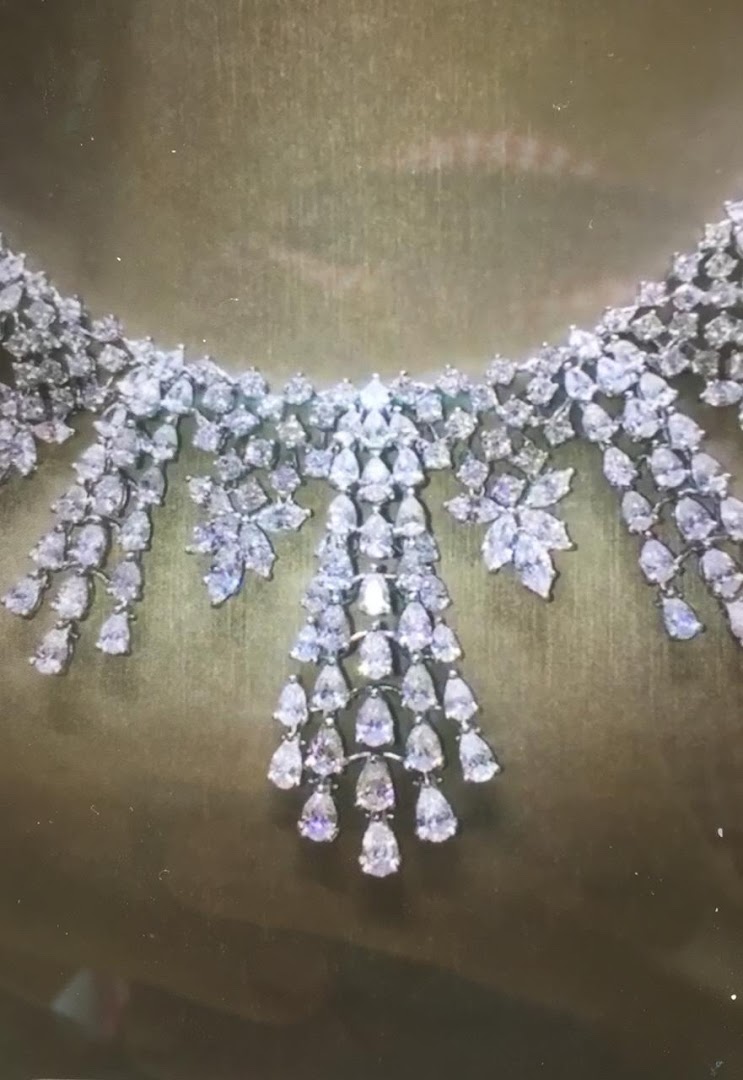 A stunning diamond necklace with intricate floral and teardrop designs.