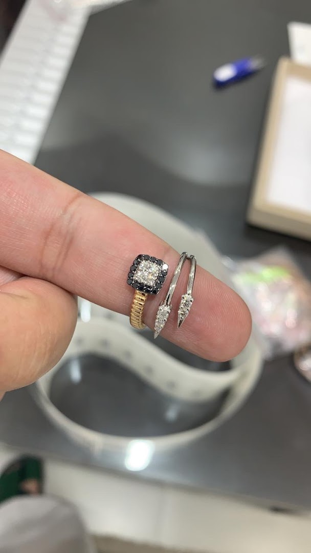 A close-up of a finger wearing two exquisite diamond rings from Lapis Jewellery.