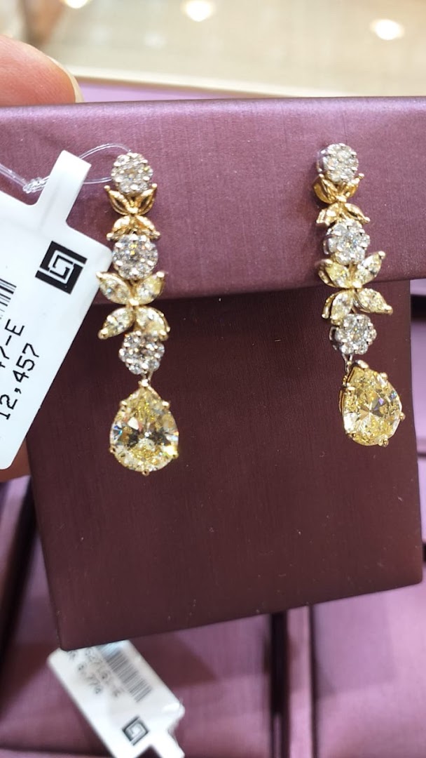 A pair of exquisite yellow diamond and diamond drop earrings with floral accents.