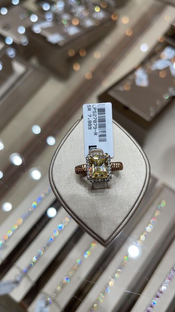 A close-up of a stunning yellow diamond ring with a rose gold band, displayed in a jewelry store.