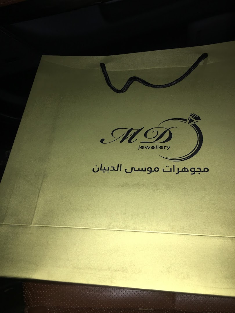 A gold shopping bag with the logo and name of a jewelry store.