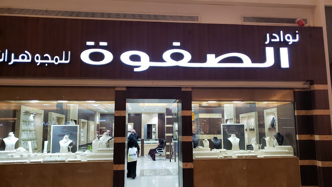 The exterior of a jewelry shop named 'مجوهرات نوادر الصفوة' with illuminated signage and display windows.