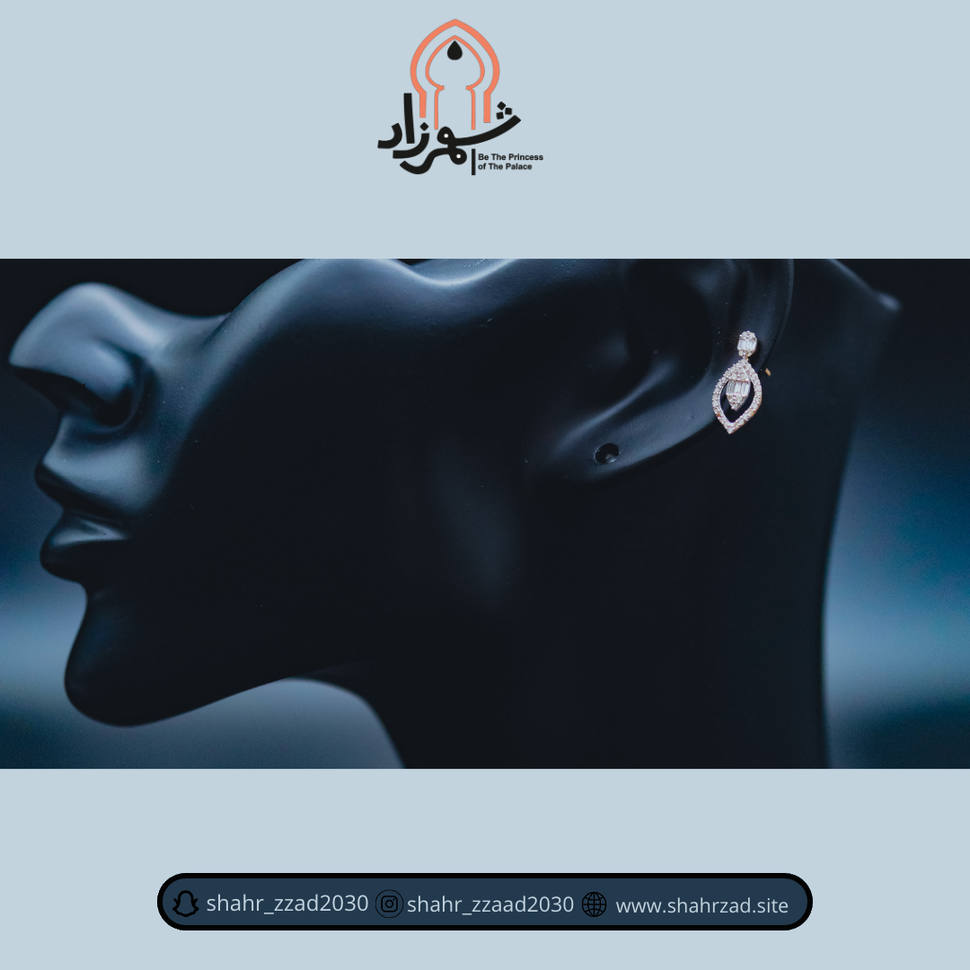A close-up of an elegant diamond earring displayed on a black mannequin head with the Shahrzad Jewelry logo.
