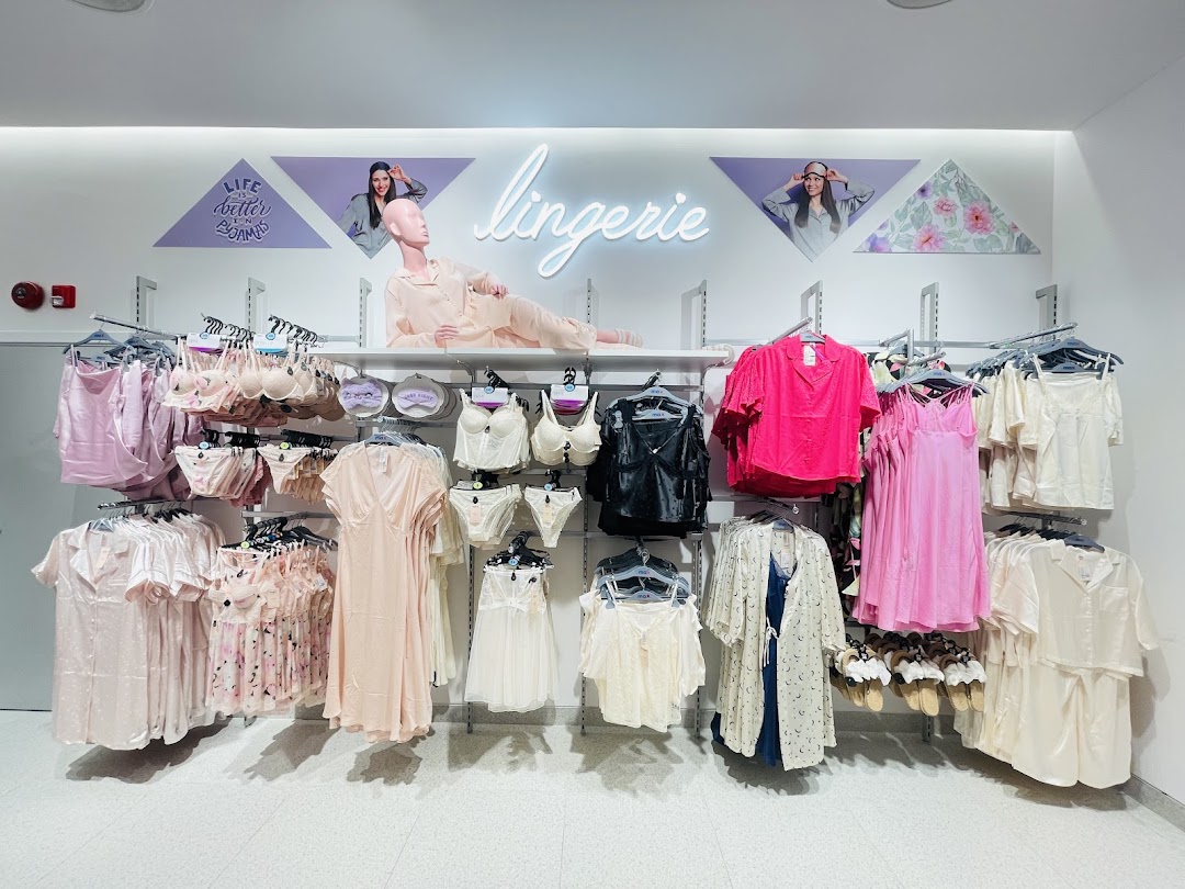 A display of lingerie and sleepwear, featuring bras, panties, and satin robes in various colors.